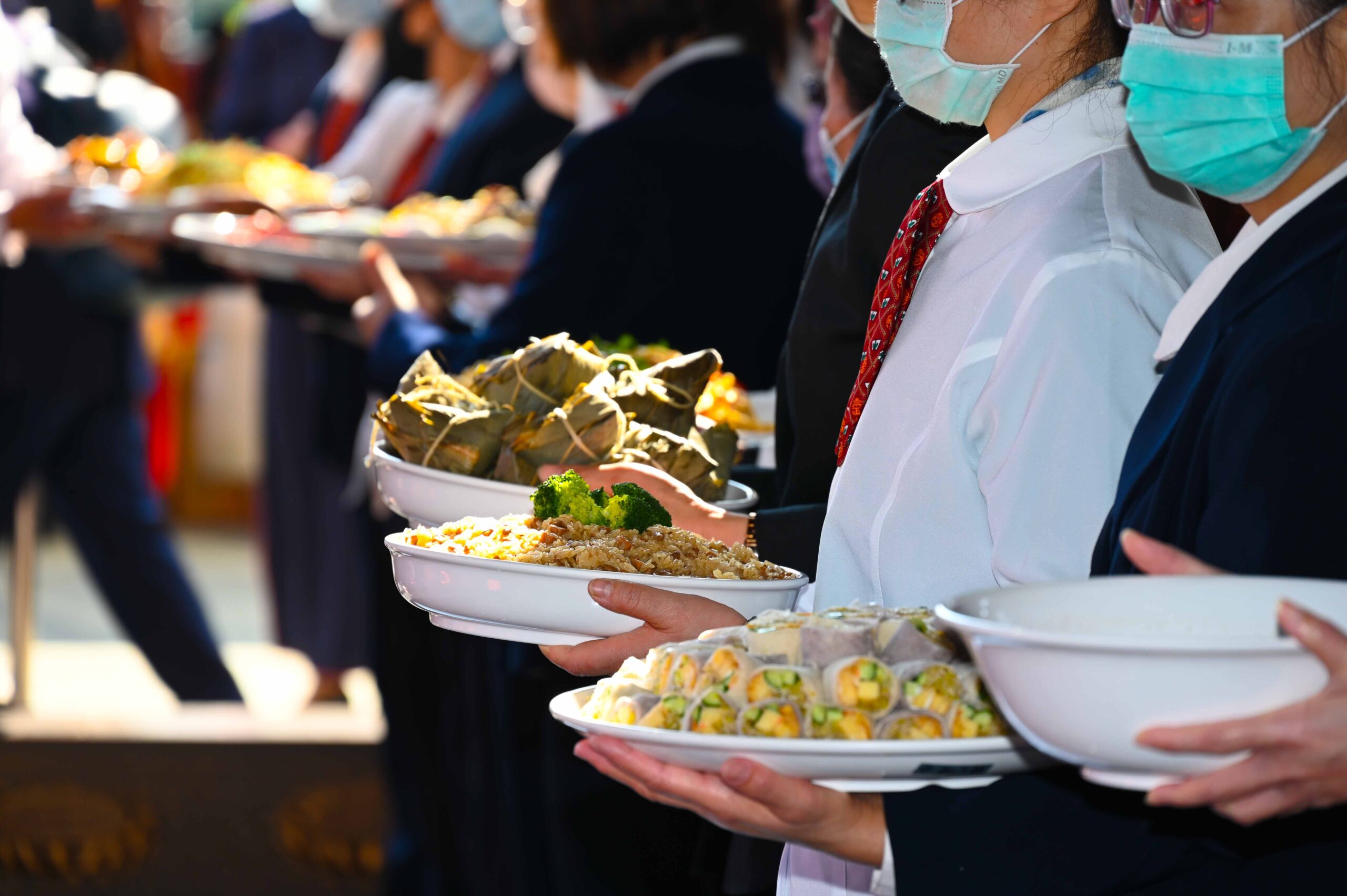 few people holding delicious dishes for worship