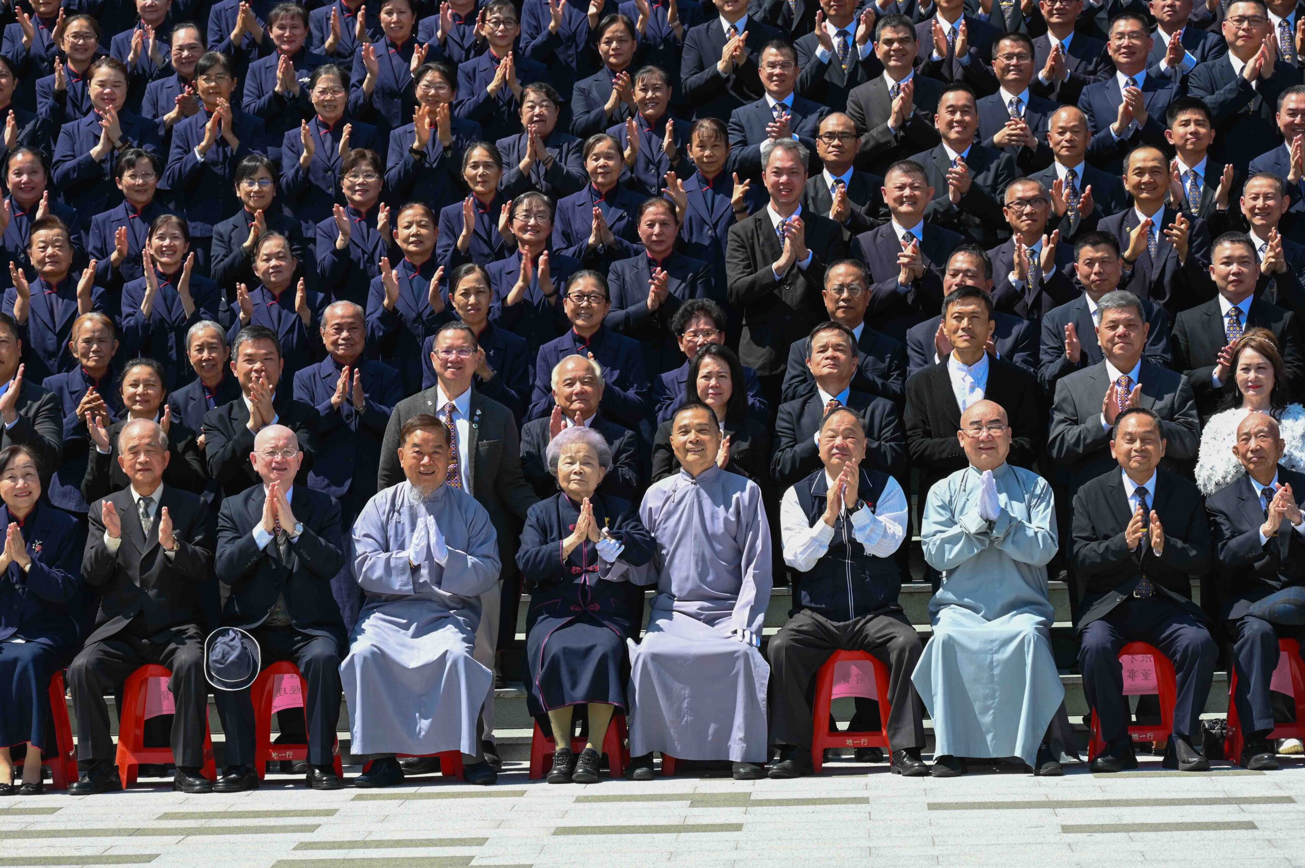 A group photo of hundreds of people in front of the hall